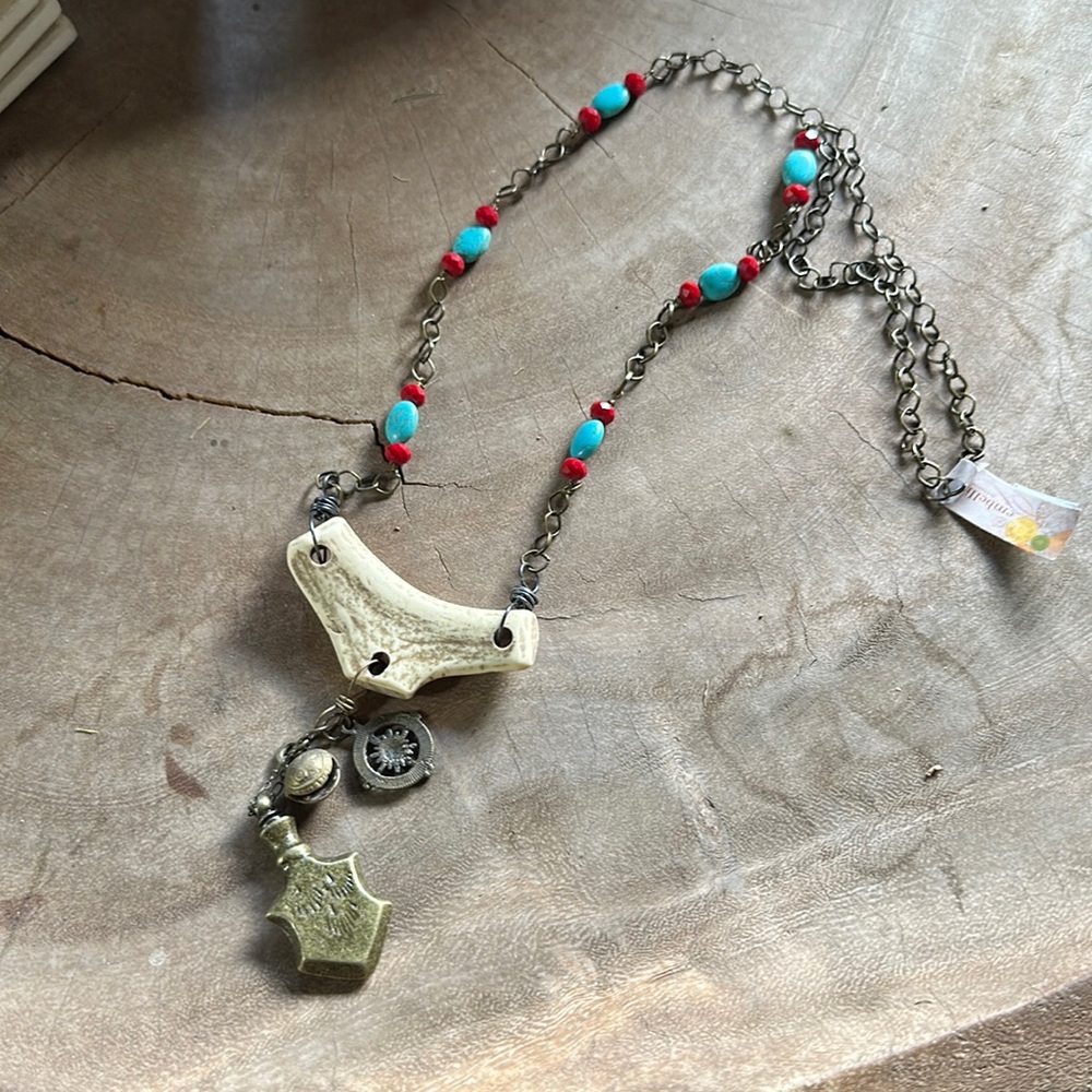 New with tags! Long necklace w/ faux bone charm and metal charm embellishments.